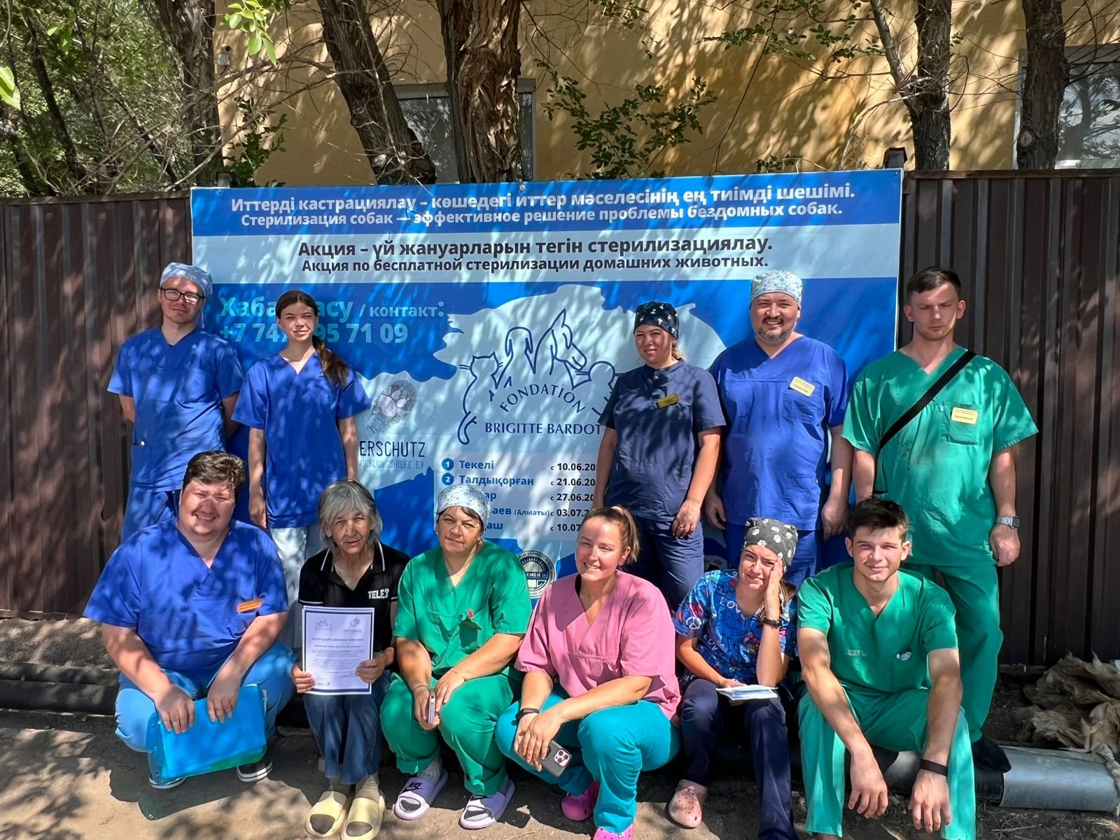 The international team of vets and volunteers beside the campaign banner